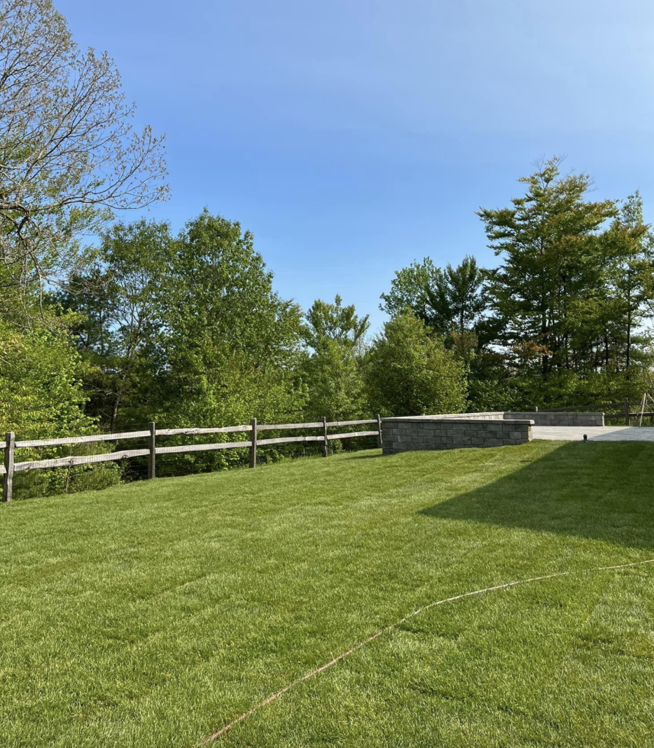 shutterstock_224187490 (1) Backyard with lush green lawn and trees in the background.